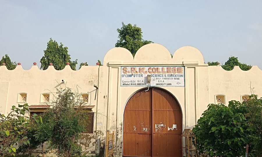 The gate of S.R.K. College in Firozabad, a cream wall with an arched brown door